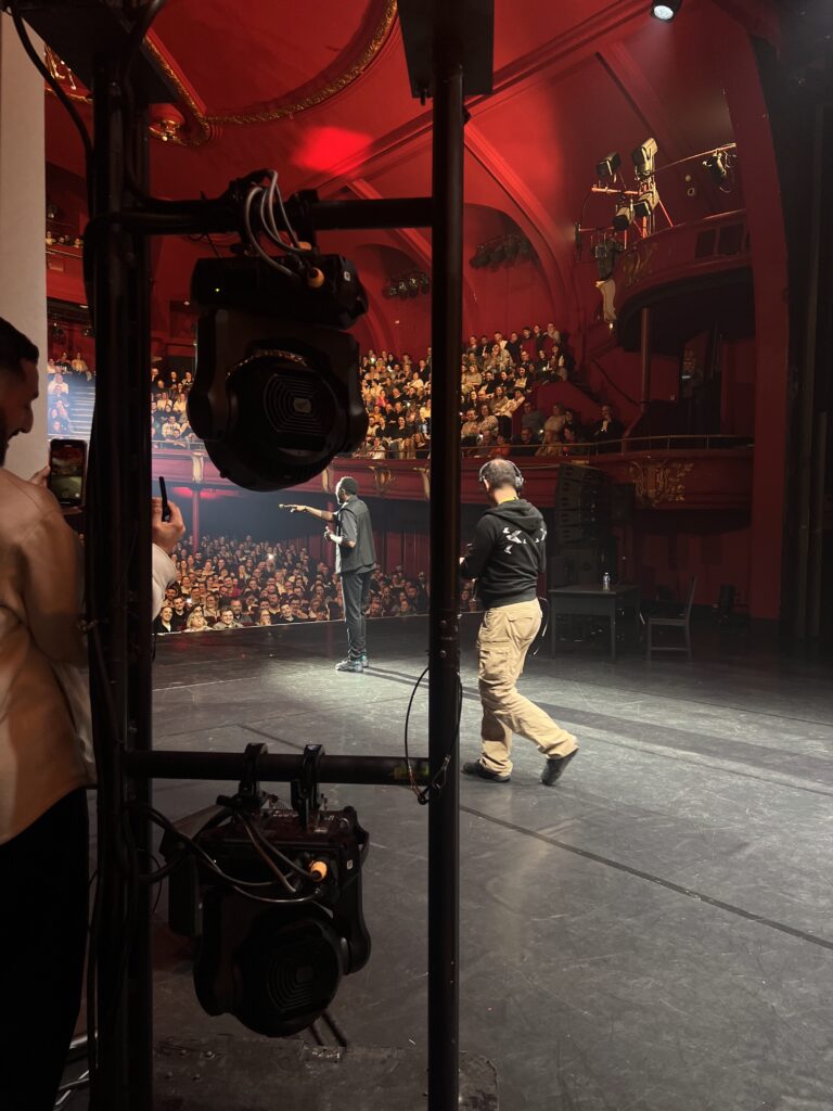 photo prise des coulisses, l'artiste sur scène ainsi que Francois, le gérant de Graffity en tant que régisseur plateau sur l'événement